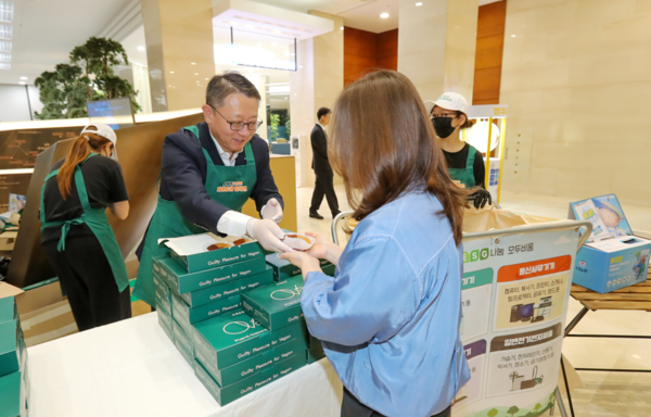 정진완 은행장이 ‘제55회 지구의 날’을 맞아 실시한 임직원 자원순환 캠페인 ‘Smart Fun(전자기기 자원순환 쉽게, 안전하게, 즐겁게!)’에서 참여한 임직원에 소정의 사은품을 전달하고 있다. [사진=우리은행]