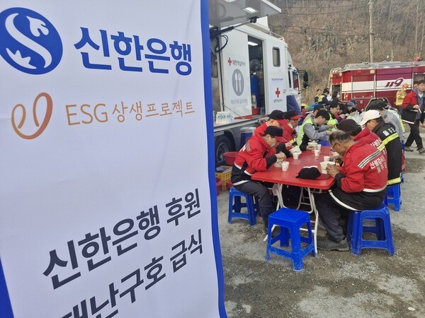 지난 3월 경북지역 산불 발생 이후 피해 복구를 위해 신한은행 후원 재난구호 급식으로 구호활동 인력들이 식사를 진행하고 있는 모습. [사진=신한은행 제공]