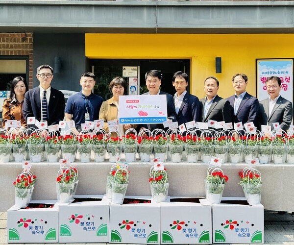 양재영 NH농협은행 리스크관리부문 부행장(왼쪽 5번째)과 임직원들이 가정의 달을 맞아 서대문종합복지관에 카네이션을 전달하고 있다. [사진=NH농협은행]