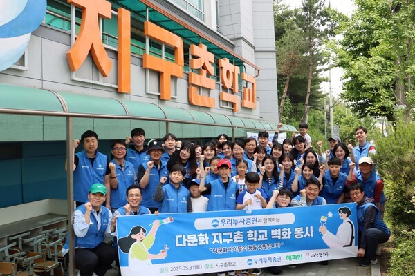 우리투자증권 임직원들이 지난달 31일 서울 구로구 ‘지구촌학교’에서 벽화 그리기 활동 후 기녀촬영을 하고 있다. [사진=우리투자증권]