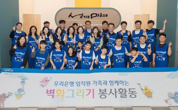 우리은행 ‘WOORI 가족봉사단’이 벽화그리기 봉사활동 후 기념촬영을 하고 있다. [사진=우리은행]