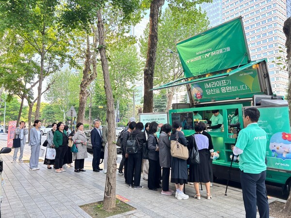 iM라이프가 진행한 브랜드데이 행사에 마련된 민트색 커피차 이벤트에 법인보험대리점(GA) 관계자들이 참여하고 있다. [사진=iM라이프]