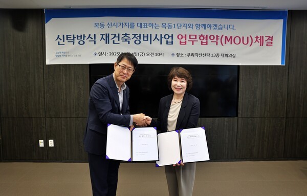 김범석 우리자산신탁 대표(왼쪽)와 정현숙 목동1단지 재건축준비위원장(오른쪽)이 업무협약식 이후 기념촬영을 하고 있다. [사진=우리자산신탁]