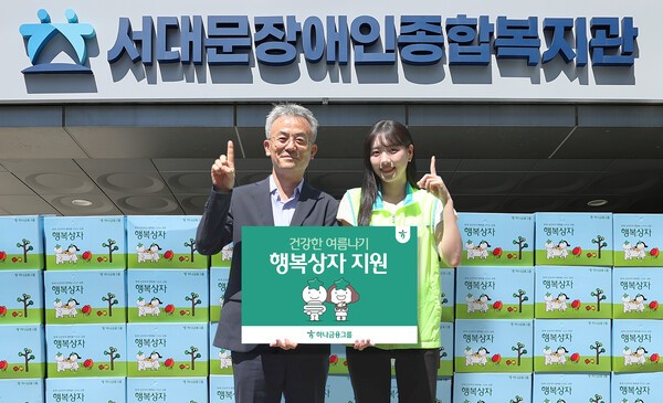 이날 행사에 참석한 하나금융그룹 직원이 송용성 서대문장애인종합복지관장(왼쪽)에게 행복상자를 전달하며 기념촬영을 하고 있다. [사진=하나금융그룹]